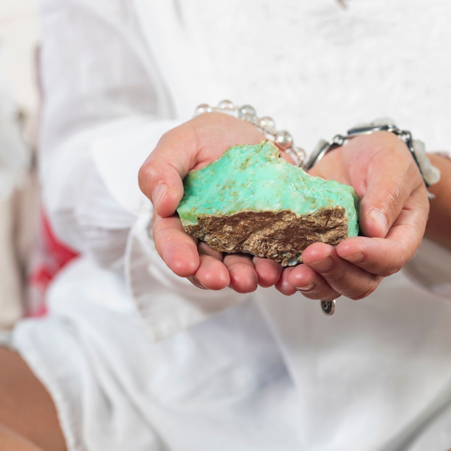Mains tenant une chrysoprase brute