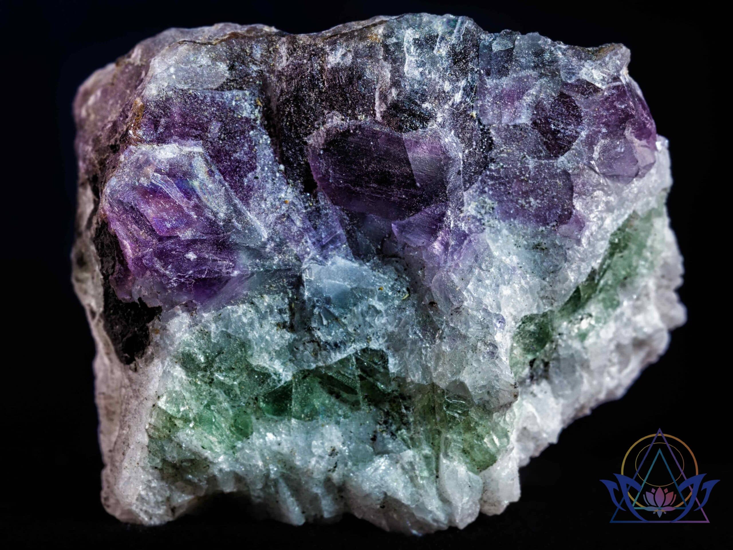 Pierre de fluorite brute aux nuances vertes et violettes montrant sa structure naturelle.
